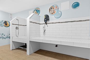 A white bathroom with a bench and a shower.